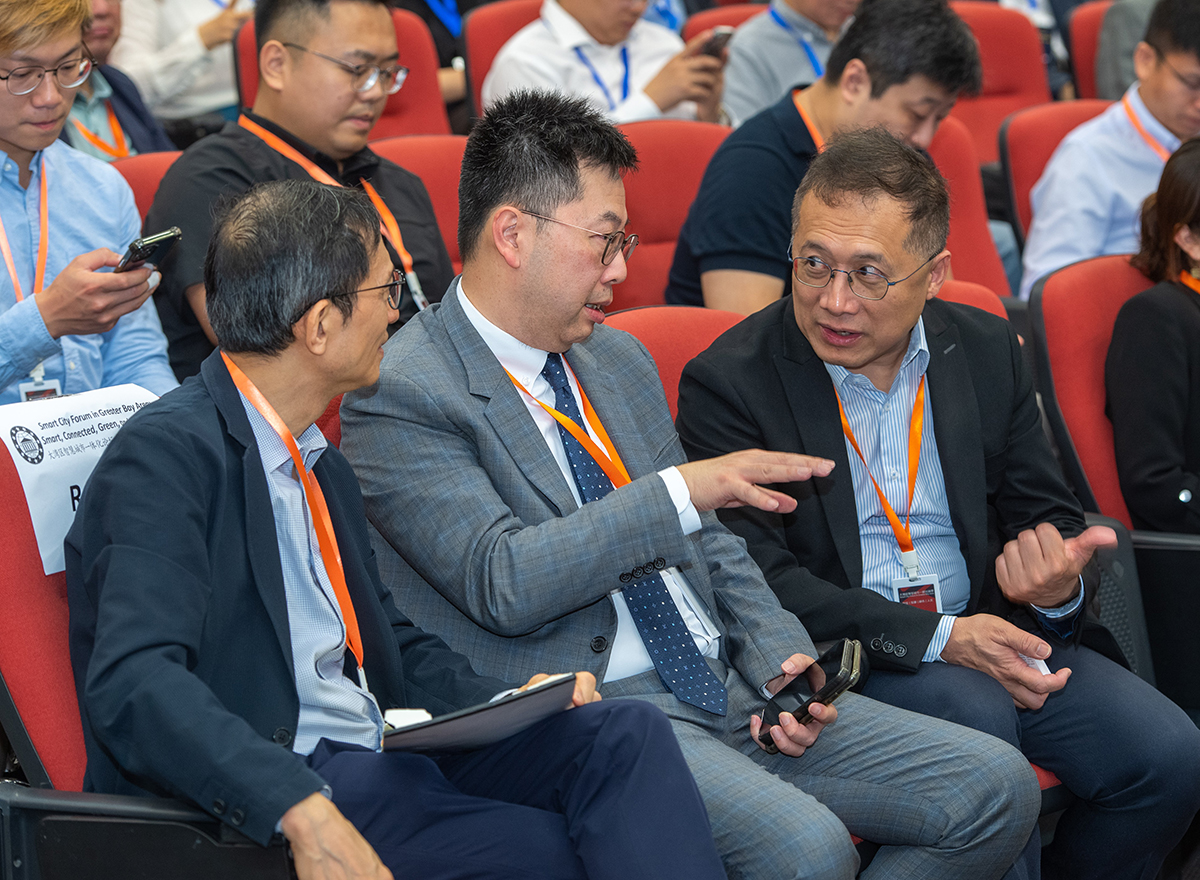 副政府资讯科技总监黄敬文（右）在五月十日于「大湾区智慧城市一体化论坛：智慧、互联、绿色、人文」上与发展局空间数据办事处总监陈宇俊（中）交流。
